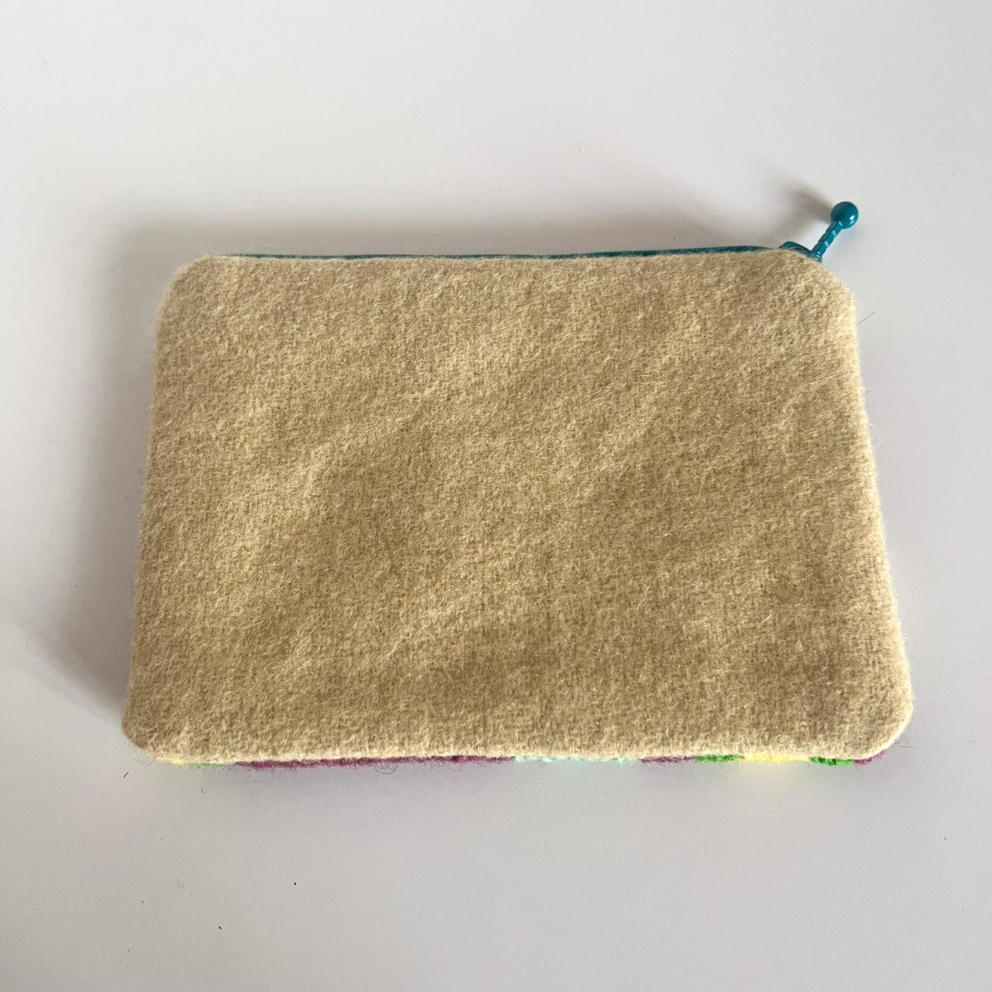 Unik handgjord nysydd börs portmonnä plånbok broderat korsstygn med ullgarn hög kvalitet från Sverige broderat med mönster stor turkos blomma med lila bakgrund och små mindre blommor i grön och mint och gult baksida vadmal ull i ljus gult