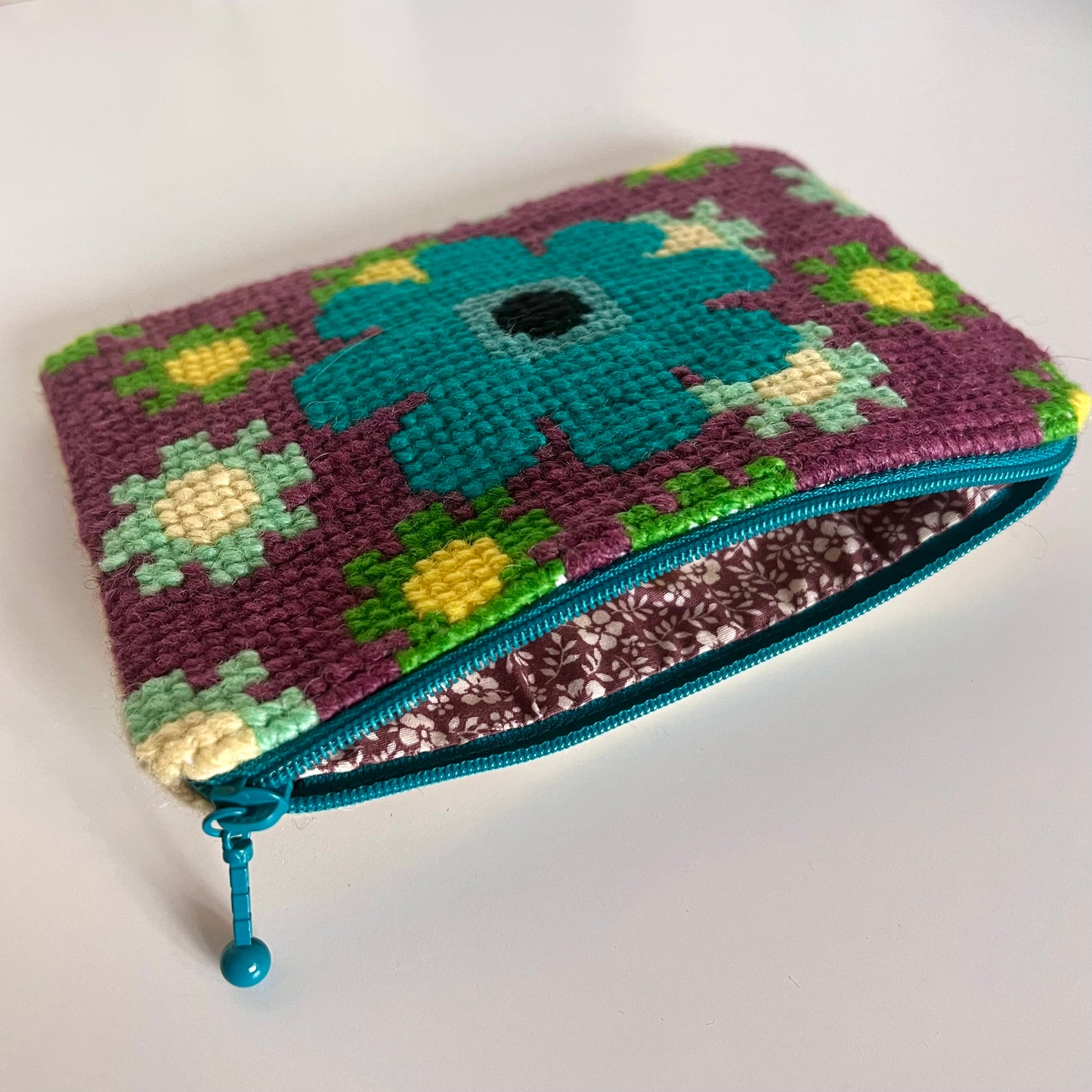 Unik handgjord nysydd börs portmonnä plånbok broderat korsstygn med ullgarn hög kvalitet från Sverige broderat med mönster stor turkos blomma med lila bakgrund och små mindre blommor i grön och mint och gult  insida bomullstyg