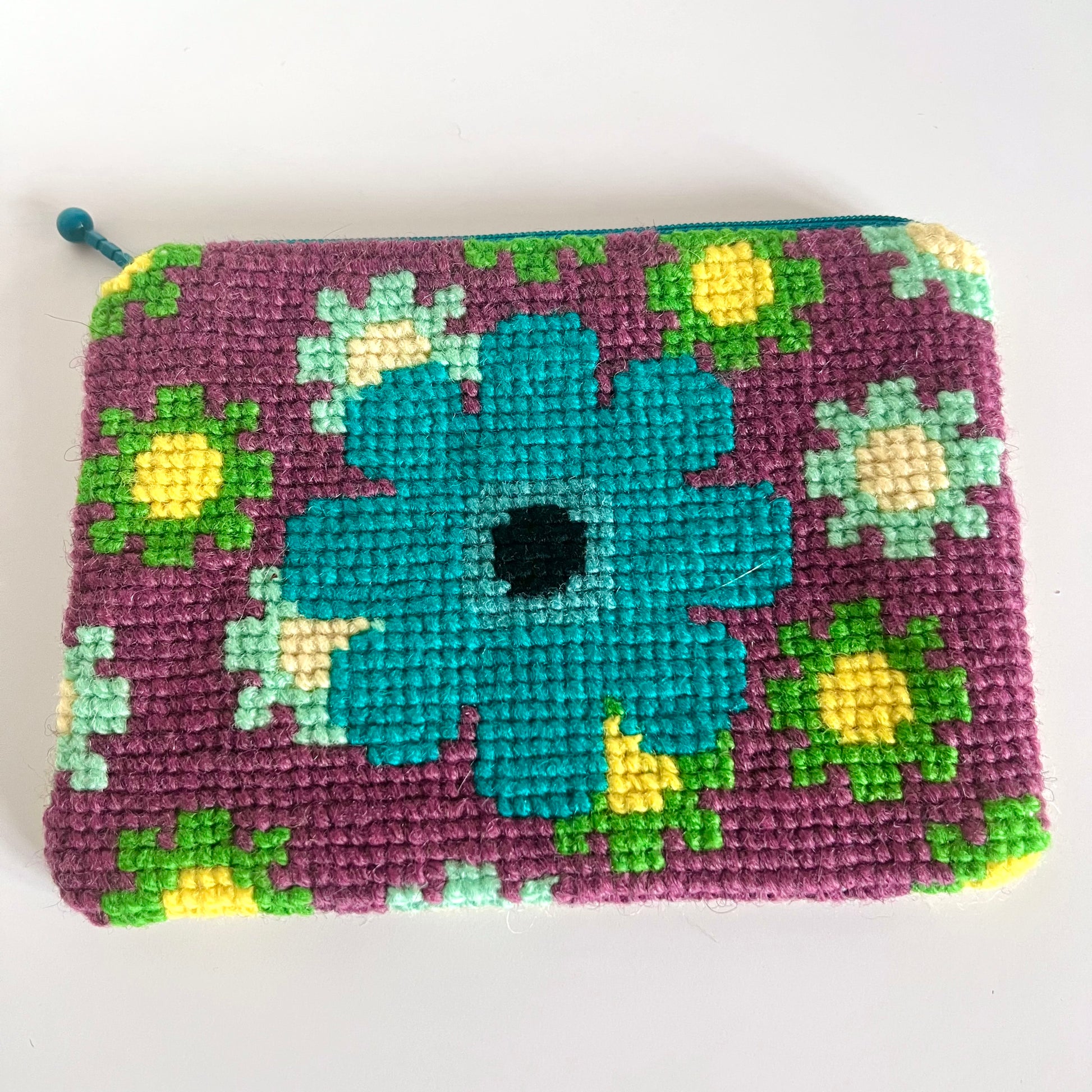 Unik handgjord nysydd börs portmonnä plånbok broderat korsstygn med ullgarn hög kvalitet från Sverige broderat med mönster stor turkos blomma med lila bakgrund och små mindre blommor i grön och mint och gult 