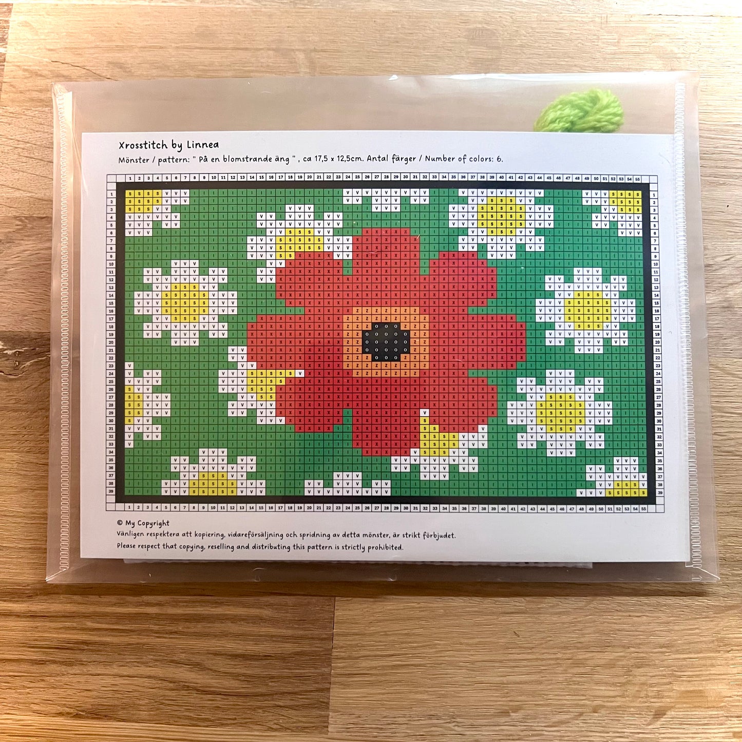 Broderikit med ullgarn på en blomstrande äng